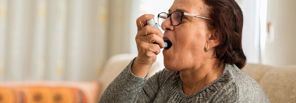 An elderly person is using an inhaler device to improve living conditions