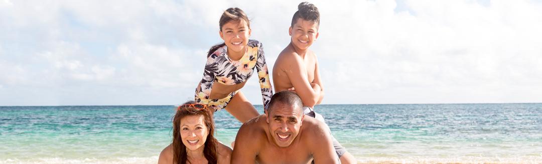 A happy family with beautiful smiles is enjoying the beach in Hawaii